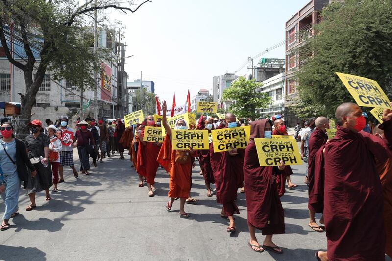 Buddhist monks holding signs lead an anti-coup protest march in Mandalay, Myanmar. AP Photo