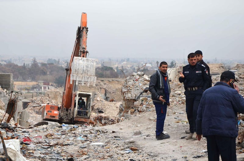 Iraqi men check a site in the city of Mosul where bodies of alleged Islamic State group jihadists remain on January 11, 2018.

For three years, jihadists made life in Iraq's Mosul impossible. Now, six months after their defeat, even their corpses are polluting everyone's existence as no one wants to move them. Amid the rubble-strewn alleys overlooking the River Tigris, unburied human remains are rotting. / AFP PHOTO / Ahmad MUWAFAQ