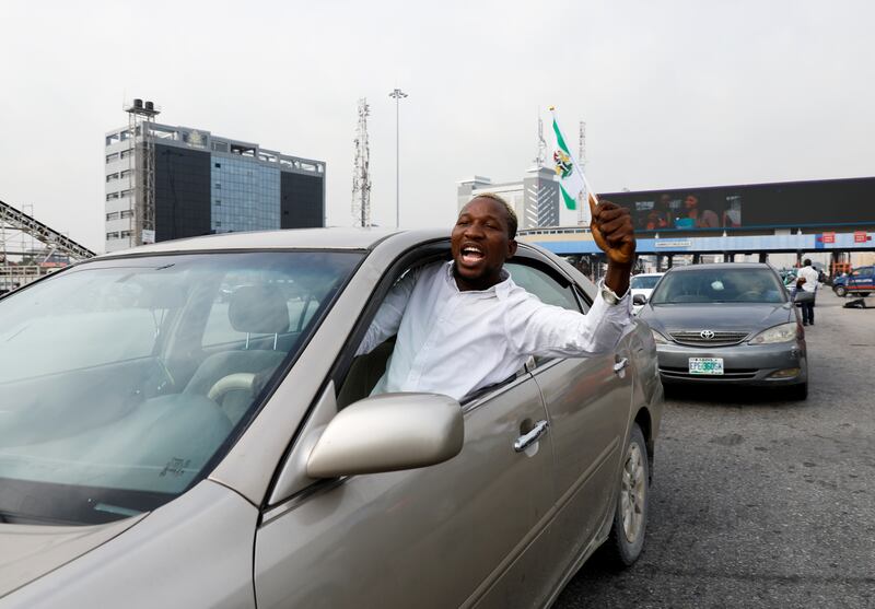 A demonstrator waves a Nigerian flag from a car window.  Reuters