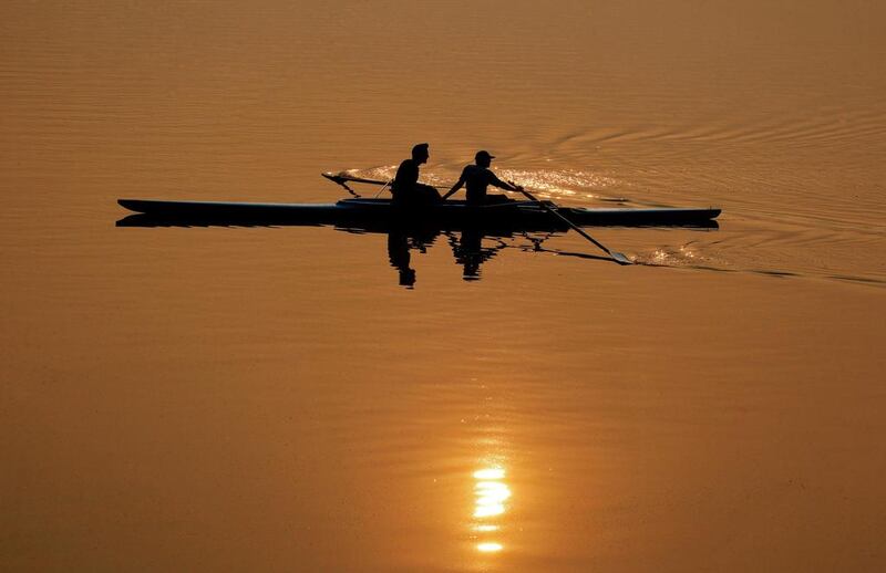 Men are silhouetted against the rising sun as they row at Sukhna Lake in Chandigarh.  Ajay Verma / Reuters
