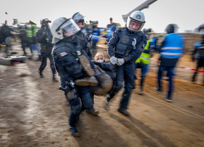 Police carry a demonstrator clear of a road at the village Luetzerath near Erkelenz, Germany. It has been occupied by climate activists protesting against the expansion of a nearby coal mine. AP