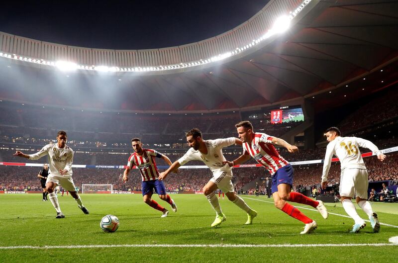 epa07878243 Real Madrid's Dani Carvajal (c) duels for the ball with Atletico Madrid's Saul Niguez (2R) during their LaLiga Primera Division soccer match played at the Wanda Metropolitano stadium, in Madrid, Spain, 28 September 2019.  EPA/JuanJo Martin
