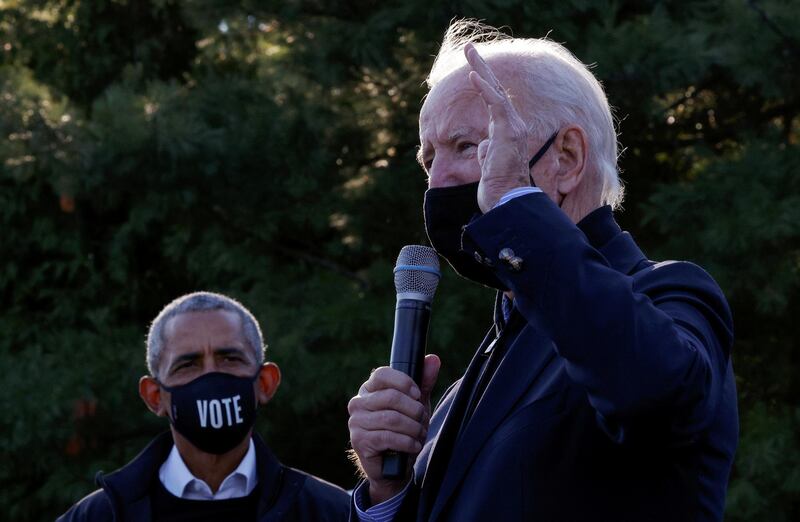 Democratic U.S. presidential nominee and former Vice President Joe Biden speaks as former U.S. President Barack Obama listens during a campaign canvas kickoff in Bloomfield Hills, Michigan, U.S., October 31, 2020.   REUTERS/Brian Snyder     TPX IMAGES OF THE DAY