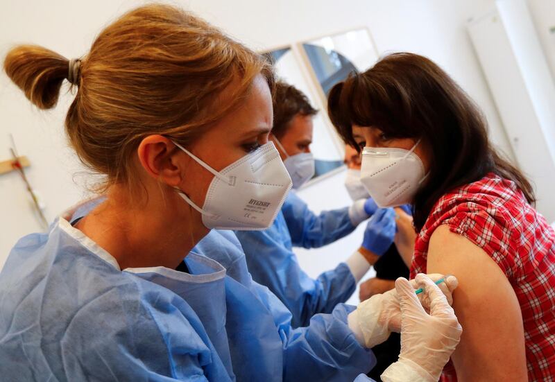 A couple receives a dose of the Pfizer-BioNTech Comirnaty coronavirus disease (COVID-19) vaccine by general practitioners Julia Erekul-Tschirner and Kerem Erekul in their doctors practice in Berlin, Germany, April 10, 2021.     REUTERS/Fabrizio Bensch