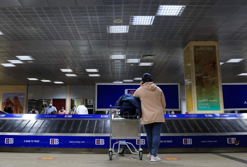 Passengers wearing protective face masks wait for their bags at the arrival area of Luxor International Airport, amid the coronavirus disease pandemic, in Luxor, Egypt. Reuters