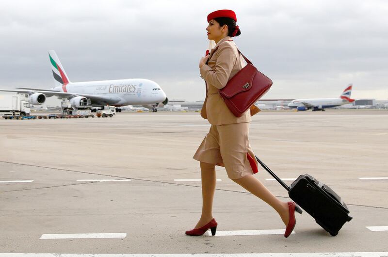 An Emirates air stewardess near one of the airline's Airbus A380 aircraft at Terminal 3 of Heathrow Airport. Bloomberg