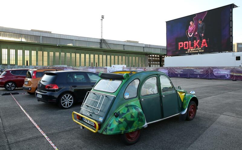 Visitors in a vintage Citroen 2CV car attend a drive-in live broadcast of the Berlin State Opera on the former airfield of Tempelhof Airport in Berlin, Germany. Getty Images