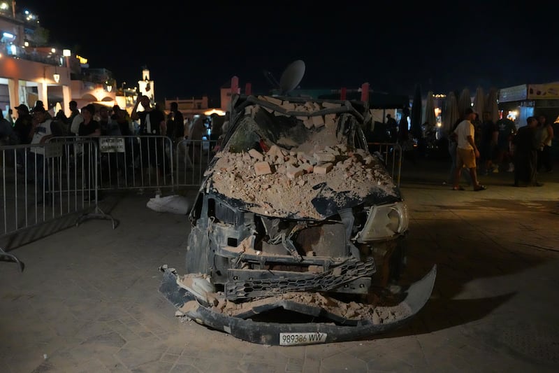 A car lies damaged under fallen rubble from a nearby building in Marrakesh. Getty Images