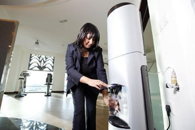 Rukhsana Kausar grabs a glass of water from one of her company's water filtration systems in Dubai last month. Sarah Dea / The National