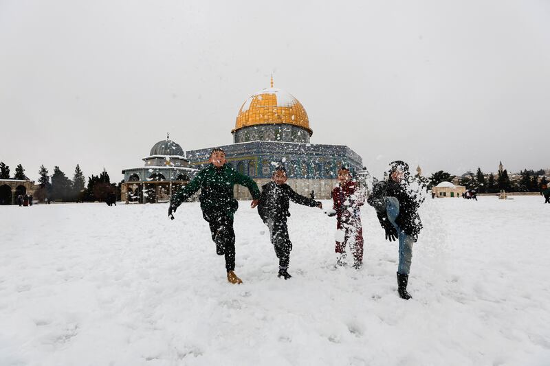 Children kick snow by the Dome of the Rock. Many of them were delighted that schools were closed. Reuters