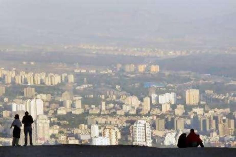 Iranians stand atop the Tochal mountainous area, as they look out onto northern Tehran, Iran, Wednesday, April 9, 2008. (AP Photo/Vahid Salemi)