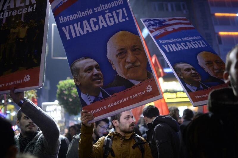 A protester holds up a placard with pictures of the Turkish prime minister Recep Tayyip Erdogan, left, and the cleric Fethullah Gülen, reading ‘We will cast them down’, during a demonstration in Istanbul in December. AFP / Bulent Kilic


