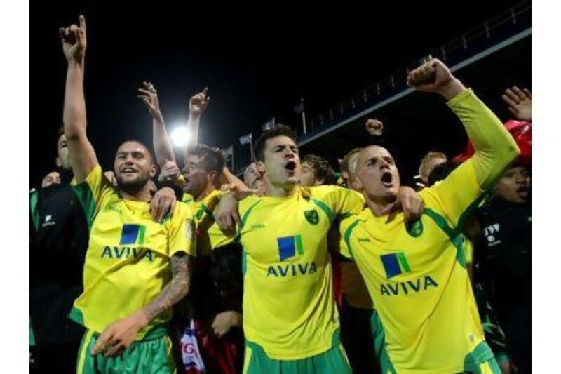 Norwich City celebrate promotion after the final whistle against Portsmouth on Monday.