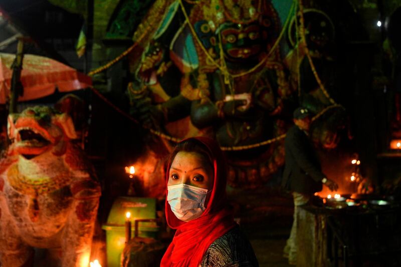A Hindu woman wears a facemask as a preventive measure against the coronavirus while visiting Durbar Square to workship in Kathmandu. AFP