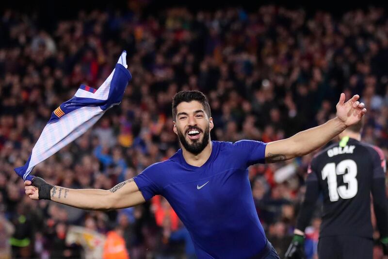 Barcelona forward Luis Suarez waves with his shirt as he celebrates scoring his side's first goal after passing Atletico goalkeeper Jan Oblak, right, during a Spanish La Liga soccer match between FC Barcelona and Atletico Madrid at the Camp Nou stadium in Barcelona, Spain, Saturday April 6, 2019. (AP Photo/Manu Fernandez)