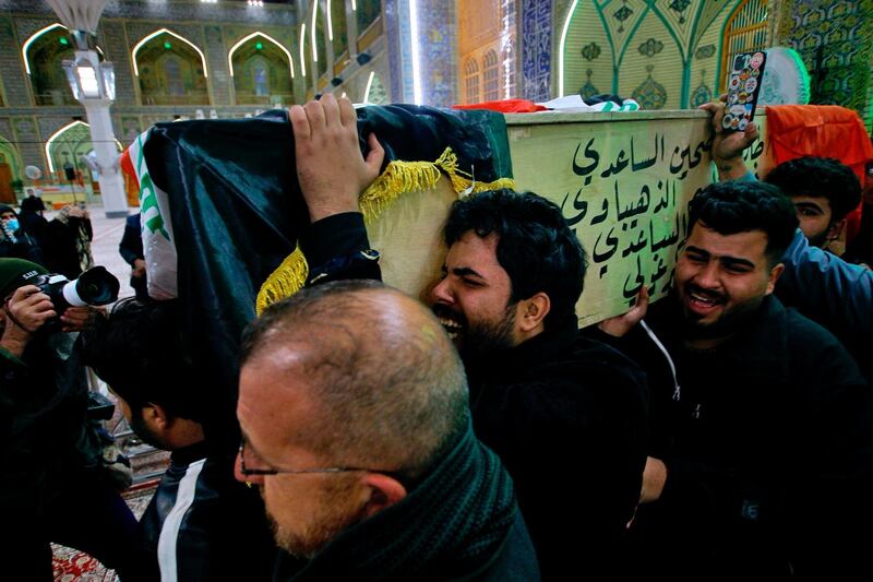 Mourners carry a flag-draped coffin of a suicide bomb victim, Ahmed Reda, during his funeral procession at the Imam Ali shrine in Najaf, Iraq, Thursday, Jan. 21, 2021. Iraq's military said twin suicide bombings at the Bab al-Sharqi commercial area in central Baghdad Thursday ripped through the busy market killing over two dozen and wounding over 70, with some in serious condition. (AP Photo/Anmar Khalil)