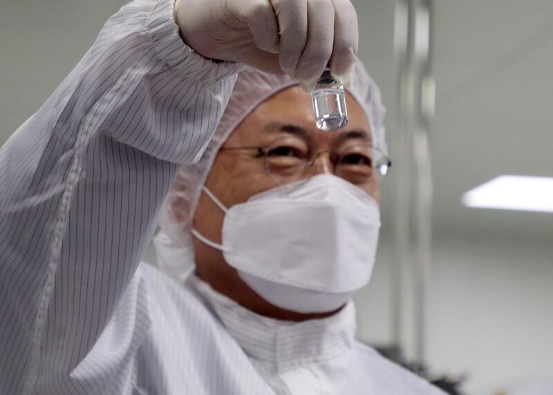 South Korean President Moon Jae-in holds a vaccine vial during a visit to a plant of South Korean bio firm SK Bioscience Co. in the southeastern city of Andong, South Korea. EPA