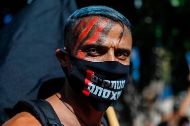 A face-painted Israeli protester wearing a protective mask amid the Covid-19 pandemic poses for a picture during a rally against Israeli Prime Minister Benjamin Netanyahu outside his official residence in Jerusalem, on July 17, 2020. AFP