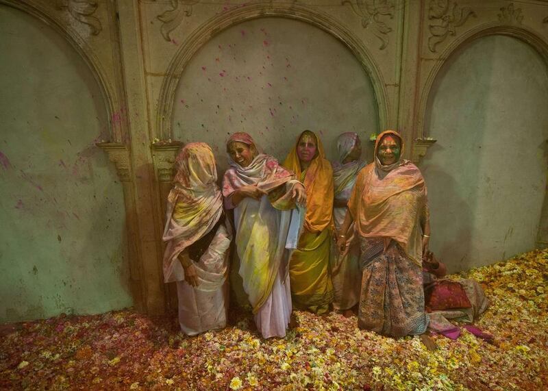 Indian widows smeared in gulal (colored powder) look on they and others participate in Holi celebrations in Vrindavan. Prakash Singh /  AFP