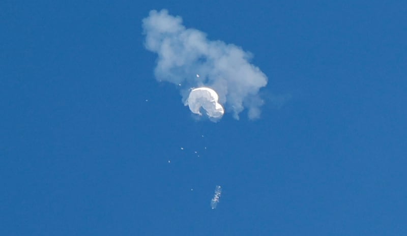 The suspected Chinese spy balloon drifts to the ocean after being shot down off the US coast, as seen from South Carolina. Reuters