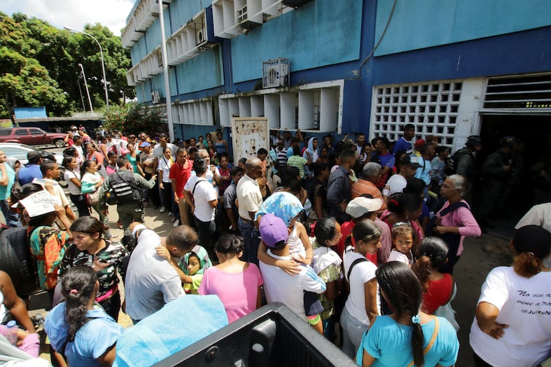 People gather outside a health centre as they wait to get treatment for malaria, in San Felix, Venezuela. Reuters