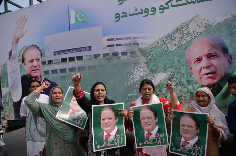 Supporters of Pakistan's ousted prime minister Nawaz Sharif hold posters of him and chant slogans as they gather at the venue where his younger brother Shahbaz Srarif will lead a rally towards the airport ahead of the arrival of Nawaz from London, in Lahore on July 13, 2018. The brother of Pakistan's ousted prime minister Nawaz Sharif on July 12 accused the country's caretaker government of "naked" pre-poll rigging against their party, as tensions rise ahead of the July 25 election. Shahbaz Sharif, who heads the Pakistan Muslim League-Nawaz, accused authorities of arresting hundreds of PML-N workers and supporters ahead of Nawaz's expected return to Pakistan on July 13.
 / AFP / AAMIR QURESHI
