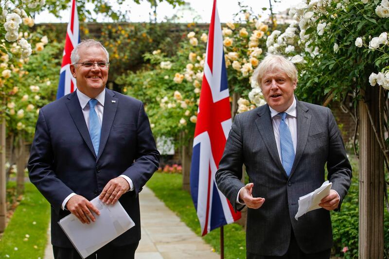 epa09272473 British Prime Minister Boris Johnson (R) and Australian Prime Minister Scott Morrison (L) give a joint news conference during their bilateral meeting in the garden of number 10 Downing Street in London, Britain, 15 June 2021. Britain is set to announce the broad terms of a free-trade deal with Australia on the day, its latest post-Brexit accord as Prime Minister Boris Johnson seeks to expand commerce beyond the European Union (EU).  EPA/LUKE MACGREGOR / POOL