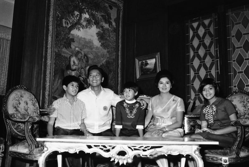 Marcos sits with his wife, Imelda, and their children, from left, Bongbong, Iren and Immee in Manila in November 1969. AP