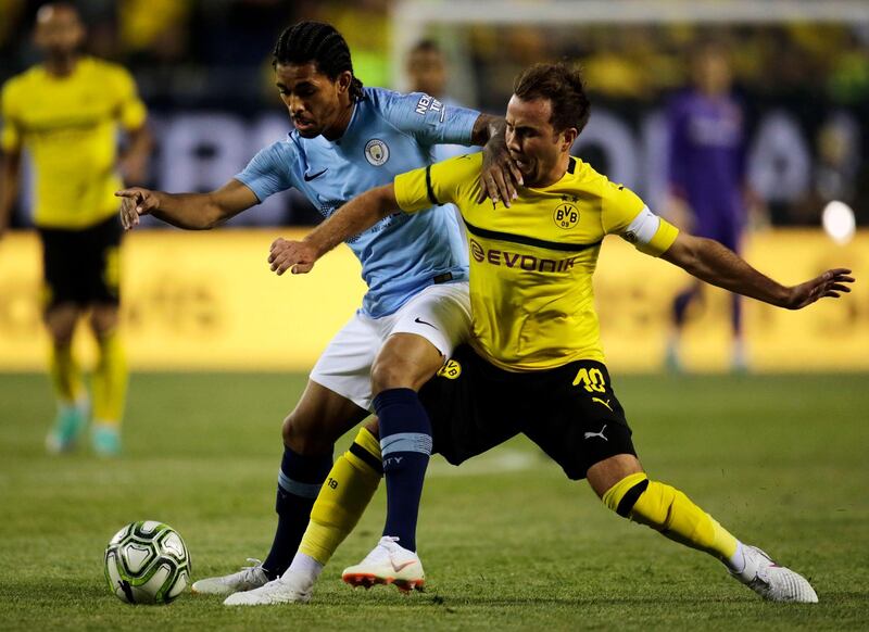 Manchester City's Douglas Luis battles over the ball with Borussia Dortmund's Mario Gotze. AP Photo