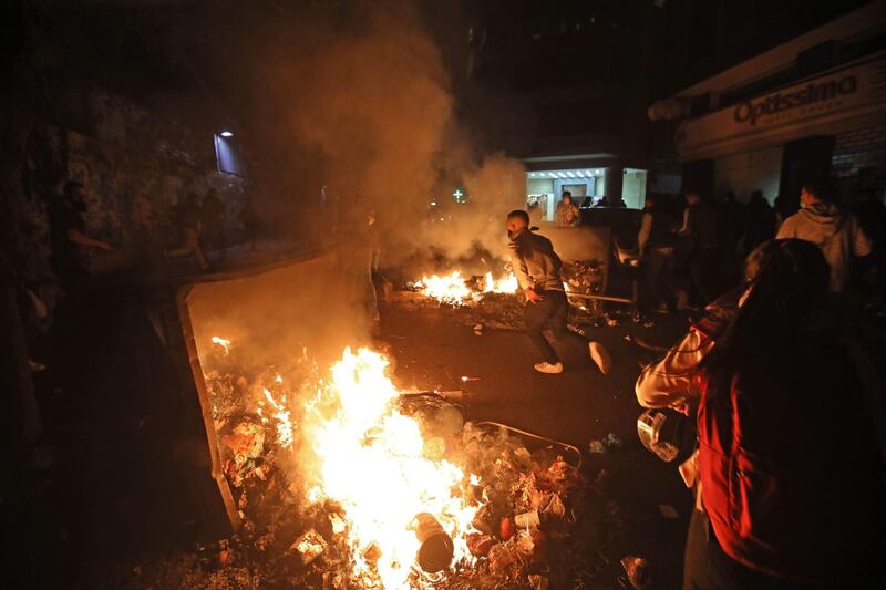 Lebanese students burn dumpsters while protesting a decision by top universities to adopt a new dollar exchange rate to price tuition in Beirut's Hamra district. AFP