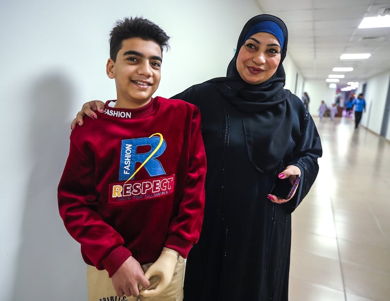 Gaza resident Malek El Khefarna, 13, with his mother. Malek was fitted with a prosthethic limb in Abu Dhabi after losing his arm in an explosion in Gaza