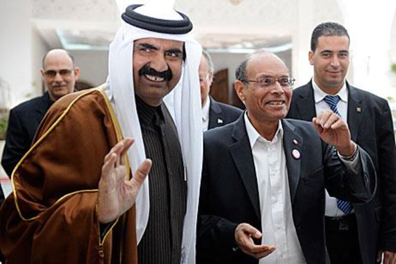 The emir of Qatar Sheikh Hamad bin Khalifa Al Thani is greeted by the Tunisian president, Moncef Marzouki, right, during a visit to Tunis last weekend for the one-year commemoration of Zine El Abidine Ben Ali’s fall. He was joined by dignitaries from the UAE, Libya, Algeria, Morocco and elsewhere.