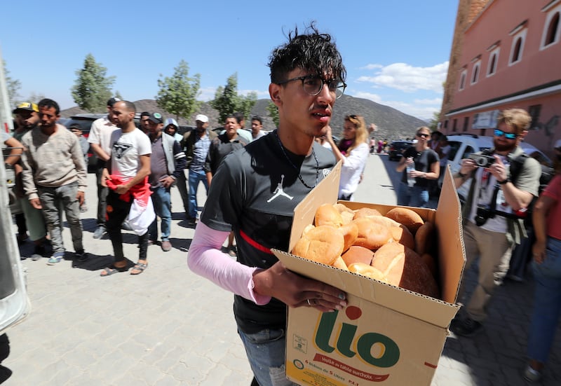 A man distributes bread to locals, in Moulay Brahim, south of Marrakesh, Morocco, following a powerful earthquake. The earthquake has affected more than 300,000 people in Marrakesh and its outskirts, the UN Office for the Coordination of Humanitarian Affairs (OCHA) said.  Morocco's King Mohammed VI declared a three-day national mourning for the victims of the earthquake. EPA