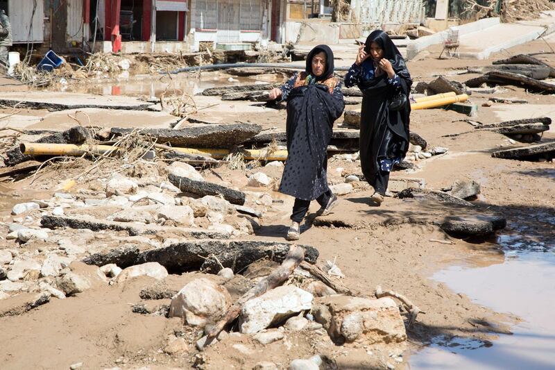 An Iranian woman walks through a flooded street in the city of Poldokhtar in the Lorestan province.   AFP