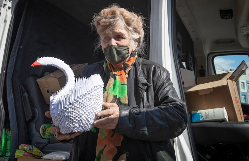 Galina Yakovleva stands by her van with an origami swan she made. AP Photo