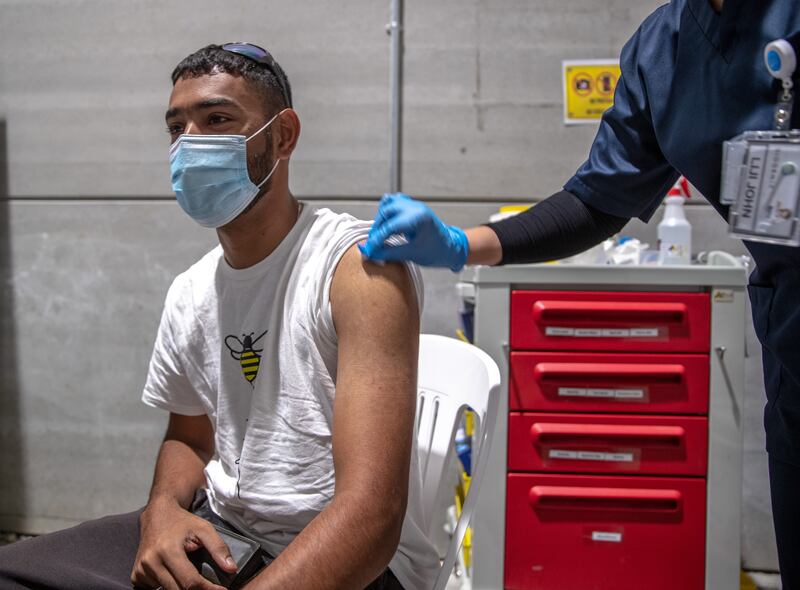 Mirza Zaib, from Pakistan, gets vaccinated at Biogenix Labs G42 in Masdar City. Victor Besa / The National