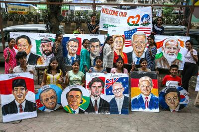 Students of Gurukul School of Art pose with portraits of G20 heads of state, in Mumbai. EPA