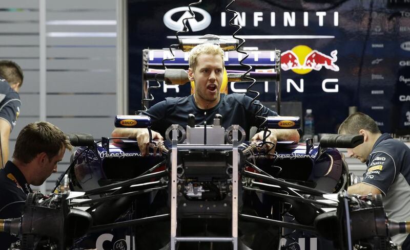 Sebastian Vettel sits in his Red Bull race car as his team mechanics prepare it for the Korean Formula One Grand Prix at the Korean International Circuit in Yeongam, South Korea, Practice starts Friday, October 3, ith a third practice and qualifying Saturday and the race Sunday. Lee Jin-man / AP Photo

