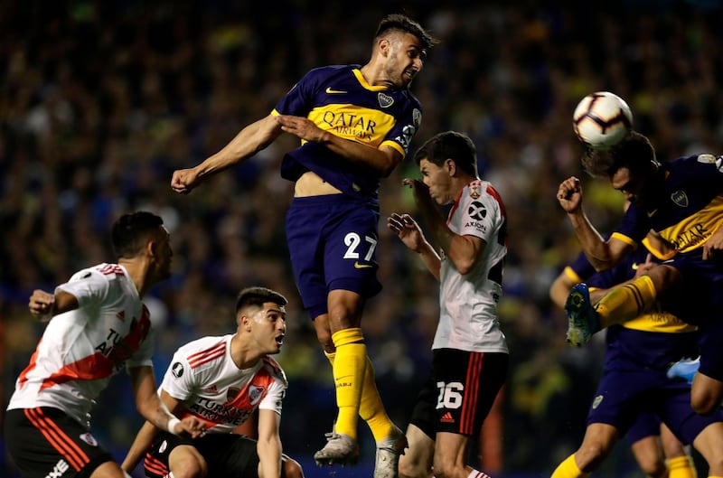Boca Juniors' Eduardo Salvio heads the ball over River Plate's Kevin Sibille during their all-Argentine Copa Libertadores semi-final second leg football match at La Bombonera stadium in Buenos Aires, on October 22, 2019. / AFP / ALEJANDRO PAGNI
