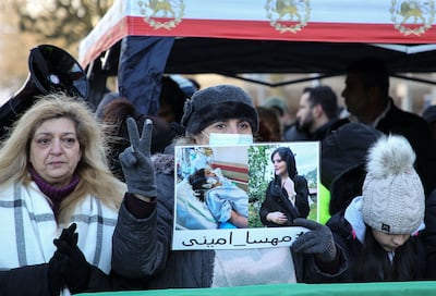 A woman holds a picture of Mahsa Amini during a protest in front of the Iranian consulate in Frankfurt, Germany, on December 16. AFP