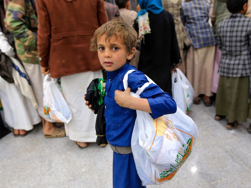 A Yemeni boy carries his bag of new garments at centre in Sanaa distributing clothes to children who have lost a parent in the conflict. AFP