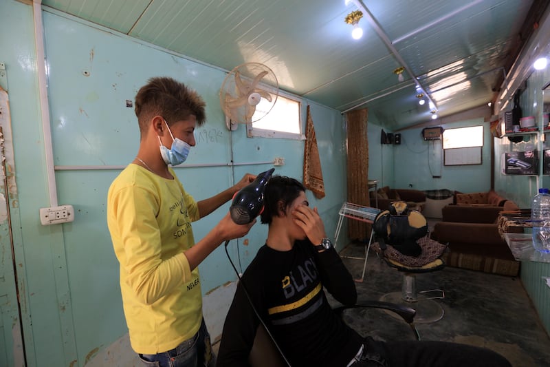 A Syrian barber at work in the camp. According to latest UNHCR data, the camp, the largest of two camps in Jordan, currently hosts 79,978 registered Syrian refugees.  EPA