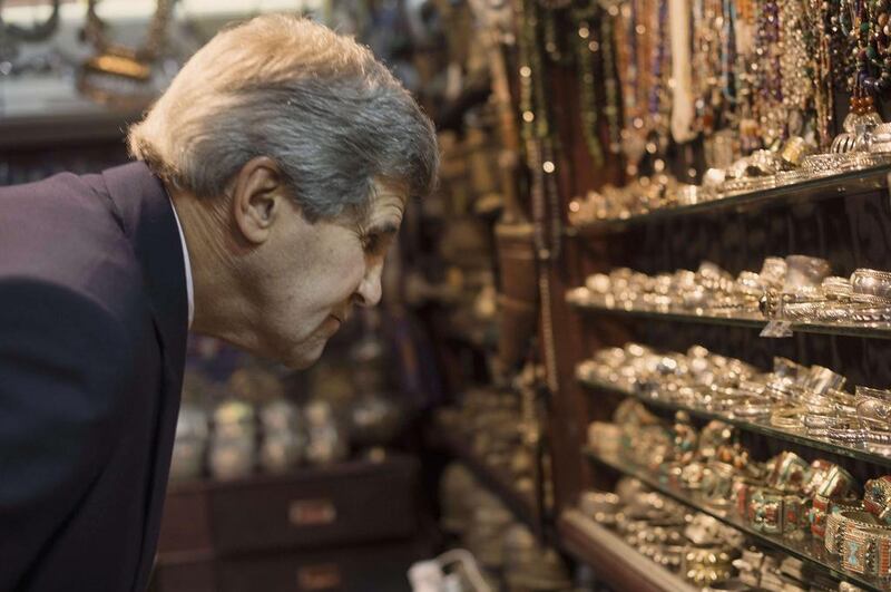 Mr Kerry looks at bracelets as he visits the Mattrah souk in Muscat on Monday. Nicholas Kamm / AP