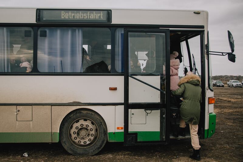 Refugees board buses towards Chisinau after crossing into Moldova.