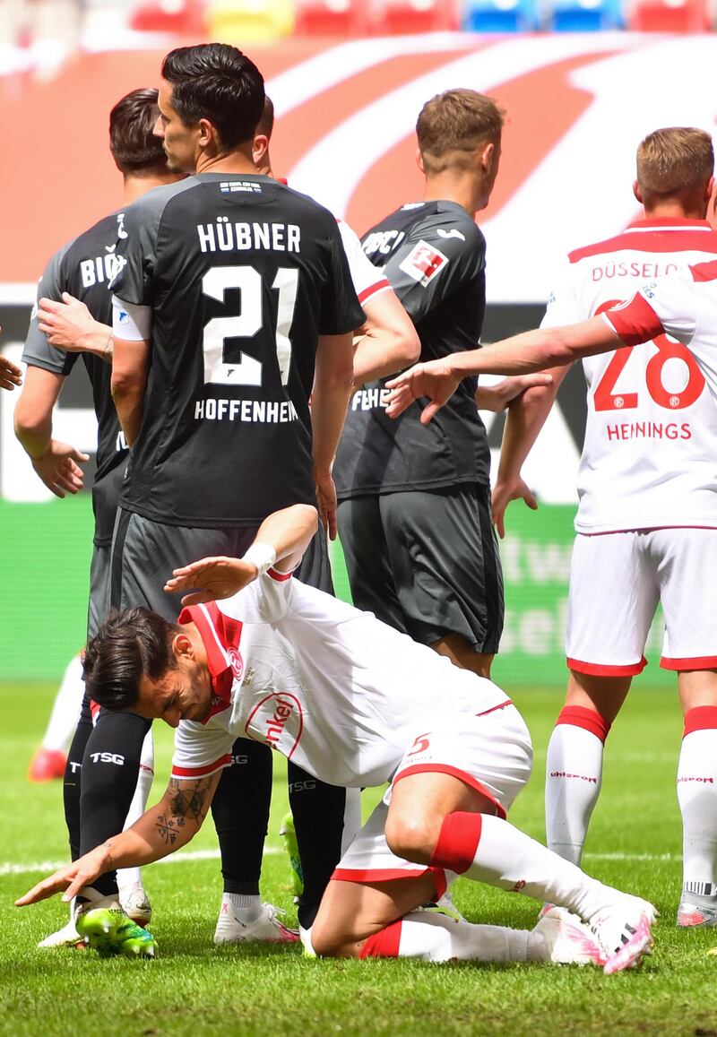 Dusseldorf's Kaan Ayhan falls to the ground after being hit in the face by Benjamin Huebner - the Hoffenheim player was sent-off as a result. AFP