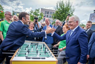 Emmanuel Macron, left, and German President Frank-Walter Steinmeier stand at a football table as they visit a democracy festival in Berlin. AP