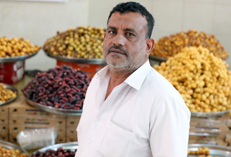 Vendor Ibrahim Abdulrahman in front of his stock. Dates are a symbol of hospitality in the UAE.