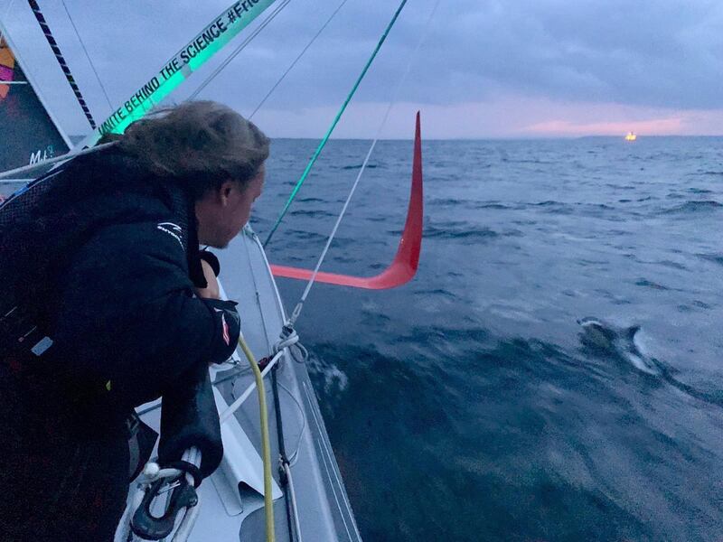 Greta watches a dolphin swimming alongside the racing boat Malizia II in the Atlantic Ocean on August 14. EPA