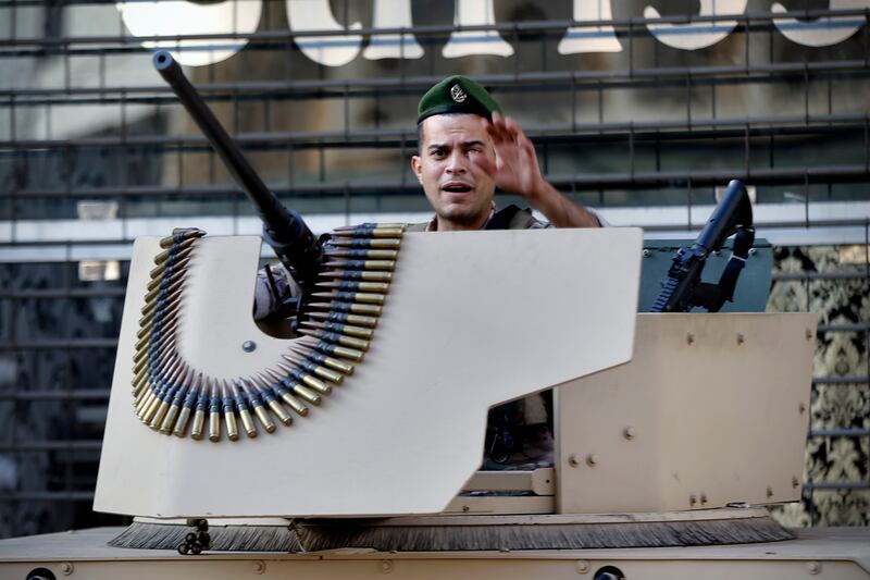 A  soldier gestures as he stands in a military vehicle. AP