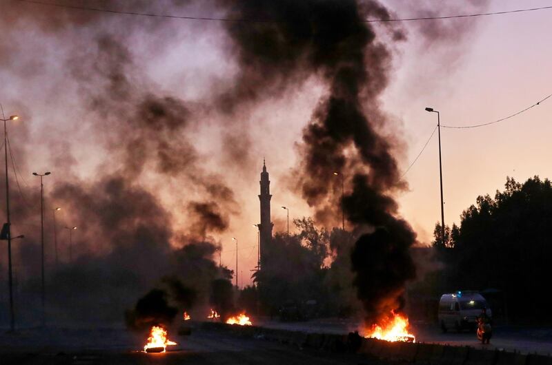 Anti-government protesters set fires and close a street during a demonstration in Baghdad, Iraq.  AP